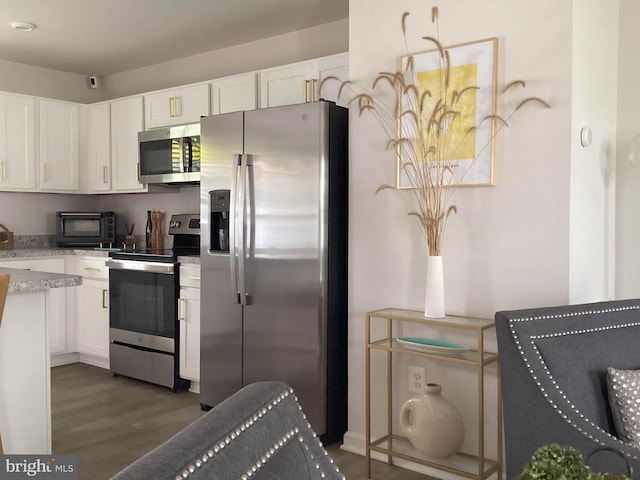 212 Bowline Dr, Cambridge, MD 21613 - kitchen featuring stainless steel appliances, white cabinets, wood finished floors, and light stone counters