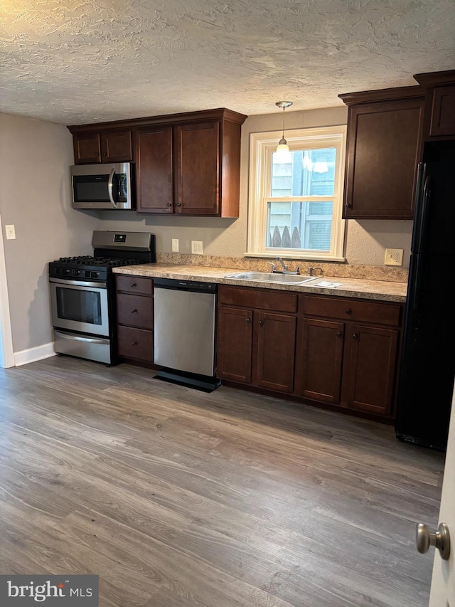 21 Girard Ave, Middletown, PA 17057 - kitchen featuring stainless steel appliances, a sink, wood finished floors, a textured ceiling, and dark brown cabinetry
