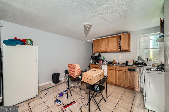 2572 Mcculloh St, Baltimore, MD 21217 - kitchen with white appliances, brown cabinetry, light tile patterned floors, a sink, and a textured ceiling