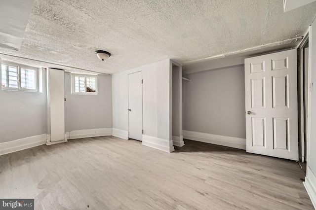 2572 Mcculloh St, Baltimore, MD 21217 - basement with light wood-style floors, a textured ceiling, and baseboards