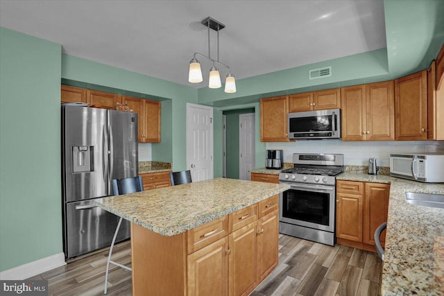 69 Calais Dr, Reading, PA 19605 - kitchen with stainless steel appliances, light wood-style flooring, a center island, decorative light fixtures, and tasteful backsplash