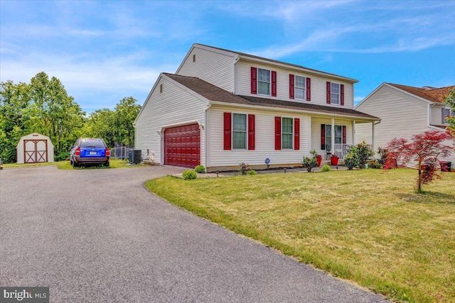 69 Calais Dr, Reading, PA 19605 - traditional-style home featuring cooling unit, covered porch, asphalt driveway, a front yard, and an attached garage