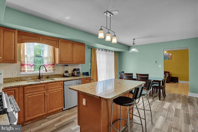 69 Calais Dr, Reading, PA 19605 - kitchen with stainless steel dishwasher, a sink, brown cabinetry, light stone counters, and tasteful backsplash