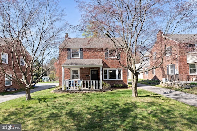 812 E Haverford Rd, Bryn Mawr, PA 19010 - traditional-style home with a front yard, covered porch, brick siding, driveway, and a chimney