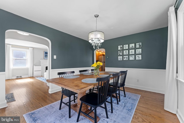812 E Haverford Rd, Bryn Mawr, PA 19010 - dining room with arched walkways, wood finished floors, and a chandelier