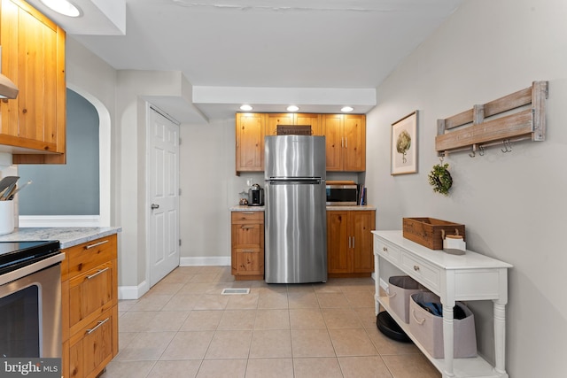 812 E Haverford Rd, Bryn Mawr, PA 19010 - kitchen featuring appliances with stainless steel finishes, light tile patterned floors, recessed lighting, arched walkways, and baseboards