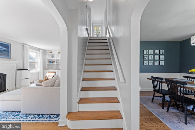 812 E Haverford Rd, Bryn Mawr, PA 19010 - stairs featuring arched walkways, wood finished floors, and a fireplace