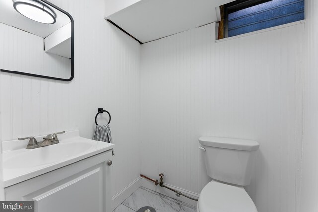 812 E Haverford Rd, Bryn Mawr, PA 19010 - bathroom featuring toilet, marble look tile flooring, vanity, baseboards, and wooden walls