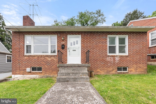 509 W Cork St, Winchester, VA 22601 - view of front of house with a chimney, brick siding, a front lawn, and entry steps