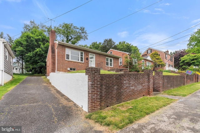 509 W Cork St, Winchester, VA 22601 - view of front of property featuring brick siding, a chimney, and driveway