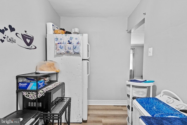 821 E Jeffrey St, Baltimore, MD 21225 - kitchen featuring wood finished floors, freestanding refrigerator, and baseboards