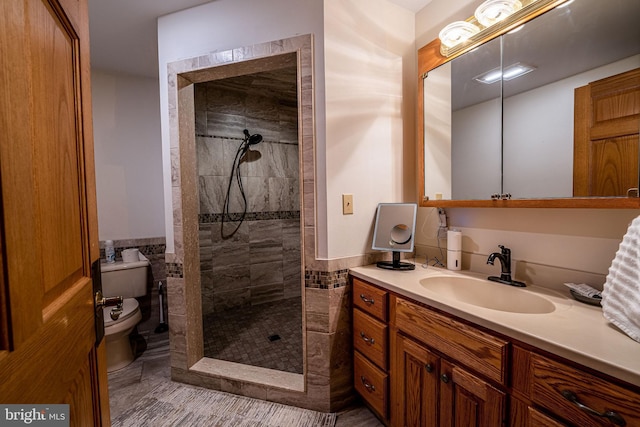 1874 Roundtop Rd, Wellsboro, PA 16901 - bathroom with a tile shower, toilet, vanity, tile walls, and wainscoting
