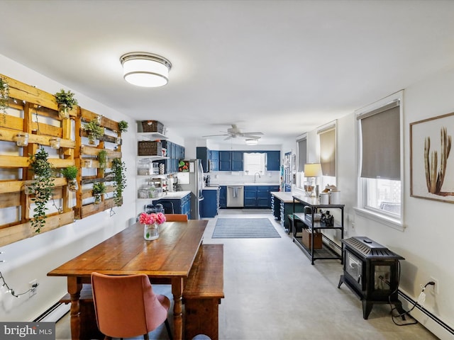25 E Potomac St, Williamsport, MD 21795 - dining space with baseboard heating, a wood stove, plenty of natural light, and a ceiling fan