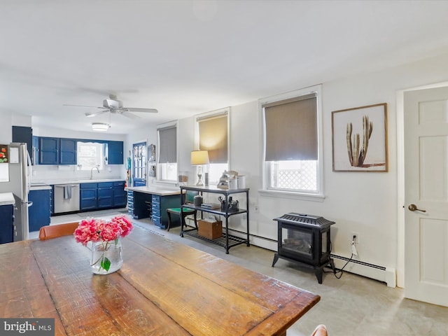25 E Potomac St, Williamsport, MD 21795 - dining room with a wood stove, a baseboard radiator, and a ceiling fan