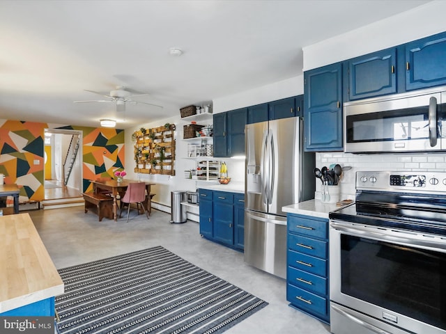 25 E Potomac St, Williamsport, MD 21795 - kitchen with stainless steel appliances, blue cabinetry, light countertops, a ceiling fan, and backsplash