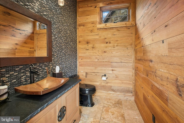 2042 Folk Rd, Fogelsville, PA 18051 - bathroom featuring wood walls, decorative backsplash, toilet, vanity, and stone finish floors
