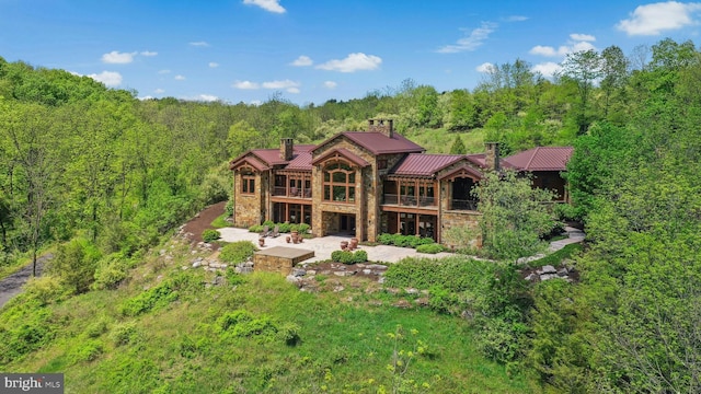 2042 Folk Rd, Fogelsville, PA 18051 - back of property with stone siding, a patio, a balcony, and a forest view