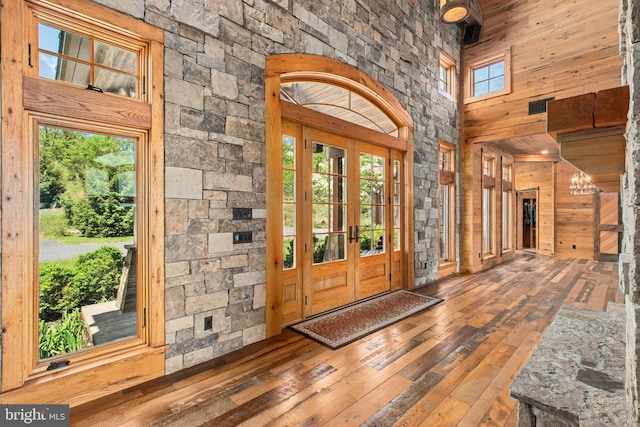 2042 Folk Rd, Fogelsville, PA 18051 - entryway featuring hardwood / wood-style floors, a high ceiling, wood walls, a chandelier, and french doors