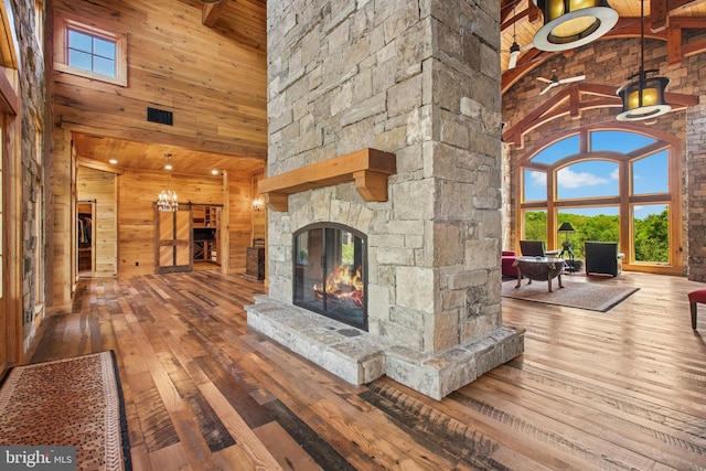 2042 Folk Rd, Fogelsville, PA 18051 - unfurnished living room featuring a high ceiling, a fireplace, hardwood / wood-style floors, wood walls, and plenty of natural light