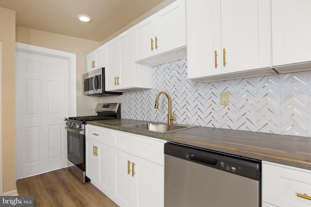 303 Coral St, Lancaster, PA 17603 - kitchen featuring appliances with stainless steel finishes, a sink, butcher block counters, backsplash, and white cabinets