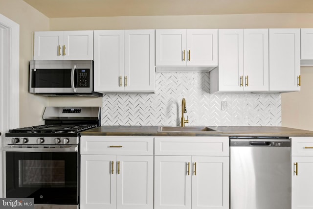 303 Coral St, Lancaster, PA 17603 - kitchen featuring appliances with stainless steel finishes, a sink, tasteful backsplash, and white cabinetry
