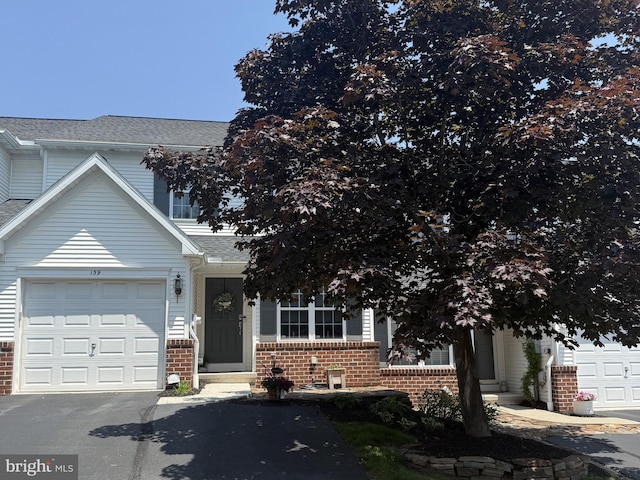 159 Waterford Ln, Reading, PA 19606 - view of property hidden behind natural elements featuring brick siding, asphalt driveway, roof with shingles, and an attached garage
