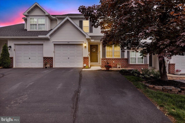 159 Waterford Ln, Reading, PA 19606 - view of property with brick siding, driveway, roof with shingles, and a garage