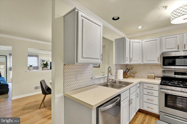 159 Waterford Ln, Reading, PA 19606 - kitchen with stainless steel appliances, a sink, decorative backsplash, light wood-style flooring, and crown molding