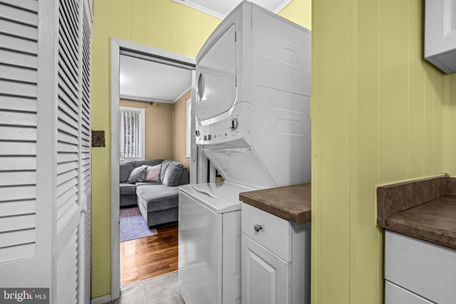 117 2nd Ave, Lindenwold, NJ 08021 - laundry room featuring stacked washer / drying machine, cabinet space, ornamental molding, and tile patterned flooring
