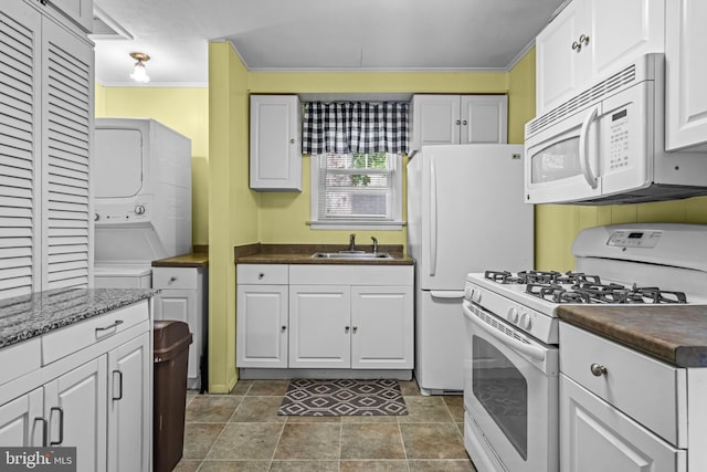 117 2nd Ave, Lindenwold, NJ 08021 - kitchen featuring white appliances, stacked washer / dryer, a sink, dark countertops, and white cabinets