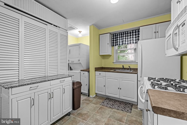 117 2nd Ave, Lindenwold, NJ 08021 - kitchen featuring white appliances, estacked washer and dryer, a sink, and white cabinets