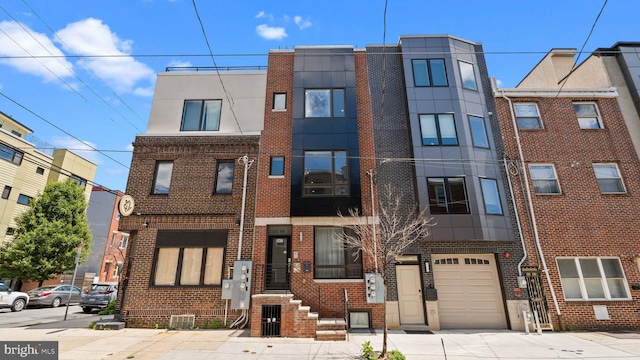 547 N 12th St Unit 2, Philadelphia, PA 19123 - view of building exterior featuring a garage and concrete driveway