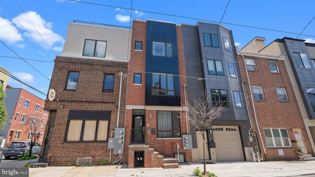 547 N 12th St Unit 2, Philadelphia, PA 19123 - view of front of home with brick siding, an attached garage, and driveway