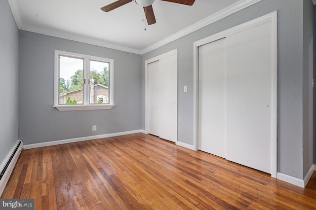 220 Firetower Rd, Port Deposit, MD 21904 - unfurnished bedroom with baseboard heating, multiple closets, crown molding, hardwood / wood-style floors, and baseboards