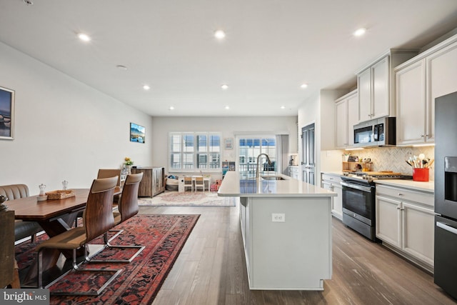 144 Bishop Way, Dublin, PA 18917 - kitchen featuring stainless steel appliances, a sink, a center island with sink, tasteful backsplash, and light countertops