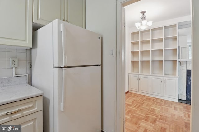 4200 Cathedral Ave NW Unit 317, Washington, DC 20016 - kitchen with freestanding refrigerator, a chandelier, and decorative backsplash