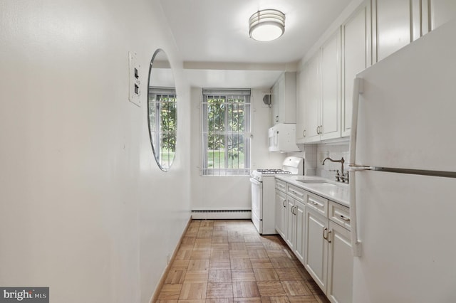 4200 Cathedral Ave NW Unit 317, Washington, DC 20016 - kitchen with white appliances, baseboard heating, a sink, and white cabinets