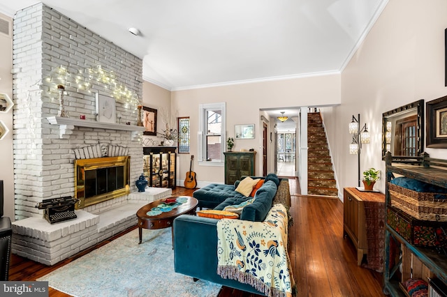 522 S Hanover St, Baltimore, MD 21201 - living room featuring hardwood / wood-style floors, crown molding, a brick fireplace, and stairs