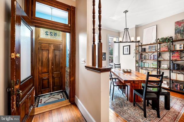 522 S Hanover St, Baltimore, MD 21201 - foyer with hardwood / wood-style floors, baseboards, ornamental molding, and a chandelier
