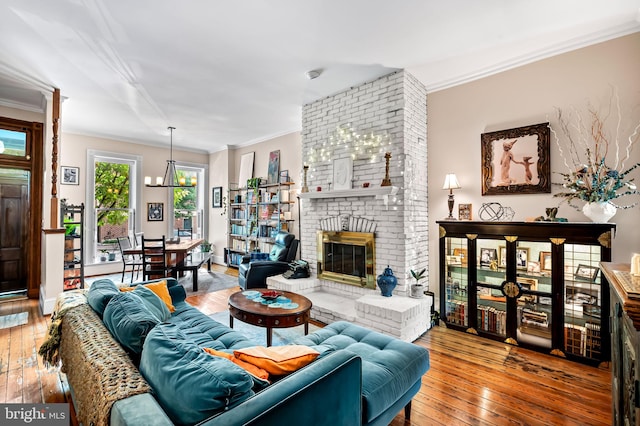 522 S Hanover St, Baltimore, MD 21201 - living room featuring hardwood / wood-style flooring, a brick fireplace, ornamental molding, and a chandelier
