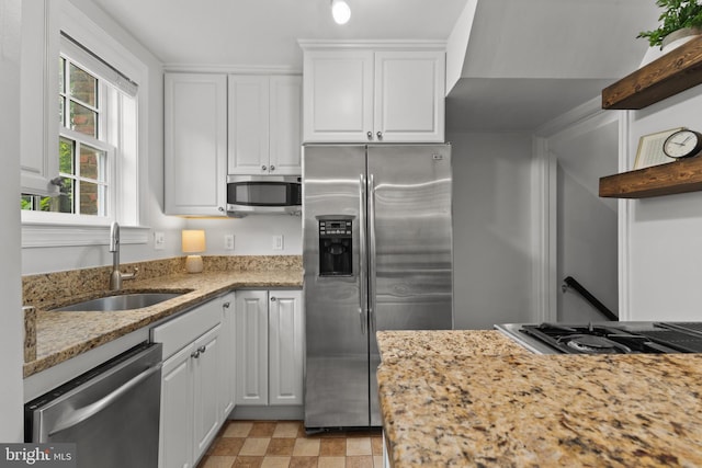 823 Church St, Alexandria, VA 22314 - kitchen with appliances with stainless steel finishes, a sink, white cabinetry, and light stone counters