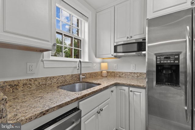 823 Church St, Alexandria, VA 22314 - kitchen featuring appliances with stainless steel finishes, a sink, white cabinets, and light stone counters