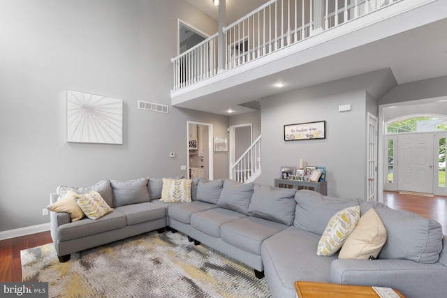 124 Willow Grove Mill Dr, Middletown, DE 19709 - living room featuring wood finished floors, stairs, a high ceiling, and baseboards