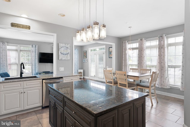 124 Willow Grove Mill Dr, Middletown, DE 19709 - kitchen featuring stainless steel dishwasher, a sink, light tile patterned flooring, baseboards, and a center island