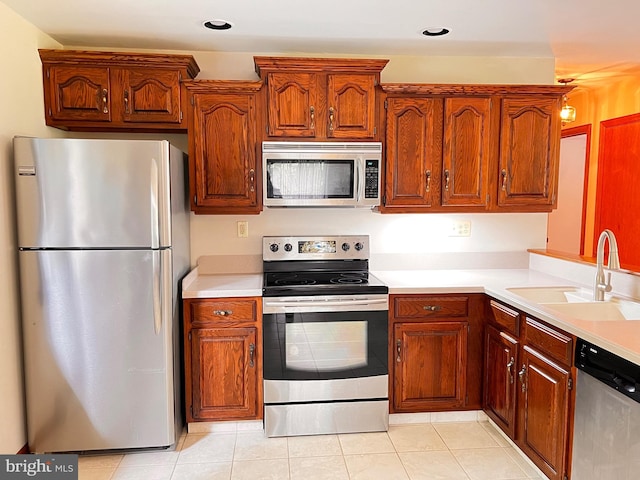 288 River Rd, Beach Lake, PA 18405 - kitchen featuring stainless steel appliances, a sink, light countertops, light tile patterned floors, and brown cabinets