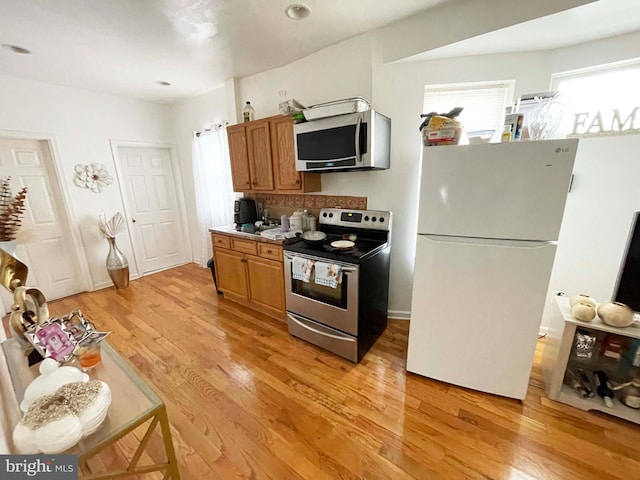 3647 N 19th St, Philadelphia, PA 19140 - kitchen with stainless steel appliances, light wood-type flooring, brown cabinets, and tasteful backsplash