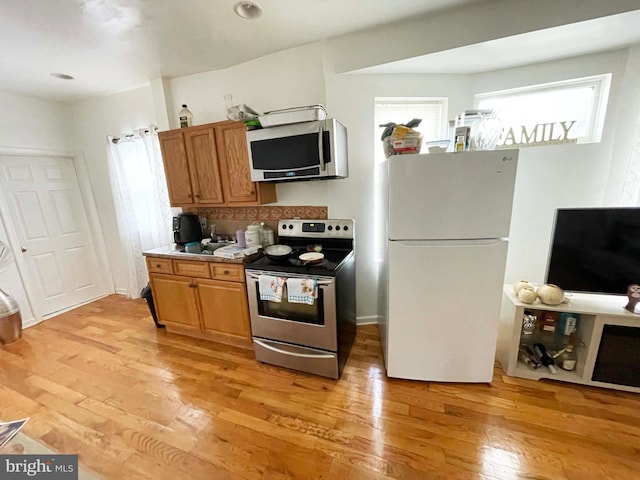 3647 N 19th St, Philadelphia, PA 19140 - kitchen featuring stainless steel appliances, light wood-type flooring, and brown cabinets
