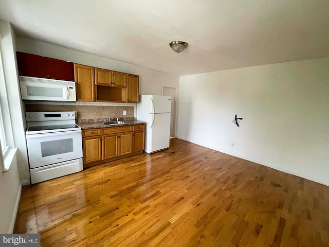 3647 N 19th St, Philadelphia, PA 19140 - kitchen with white appliances, a sink, light wood-style flooring, dark countertops, and brown cabinetry