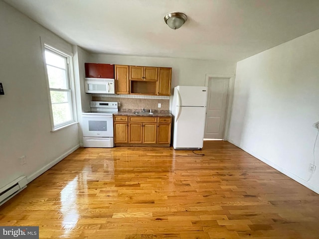3647 N 19th St, Philadelphia, PA 19140 - kitchen featuring white appliances, a sink, tasteful backsplash, light wood finished floors, and a baseboard radiator