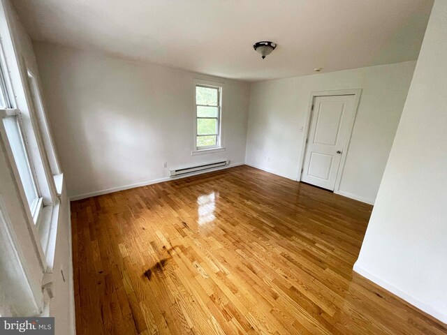 3647 N 19th St, Philadelphia, PA 19140 - unfurnished room with a baseboard heating unit, wood finished floors, and baseboards